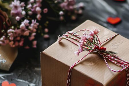 gift box with ribbon tied around it bouquet flowers background scaled Wilcza Jagoda